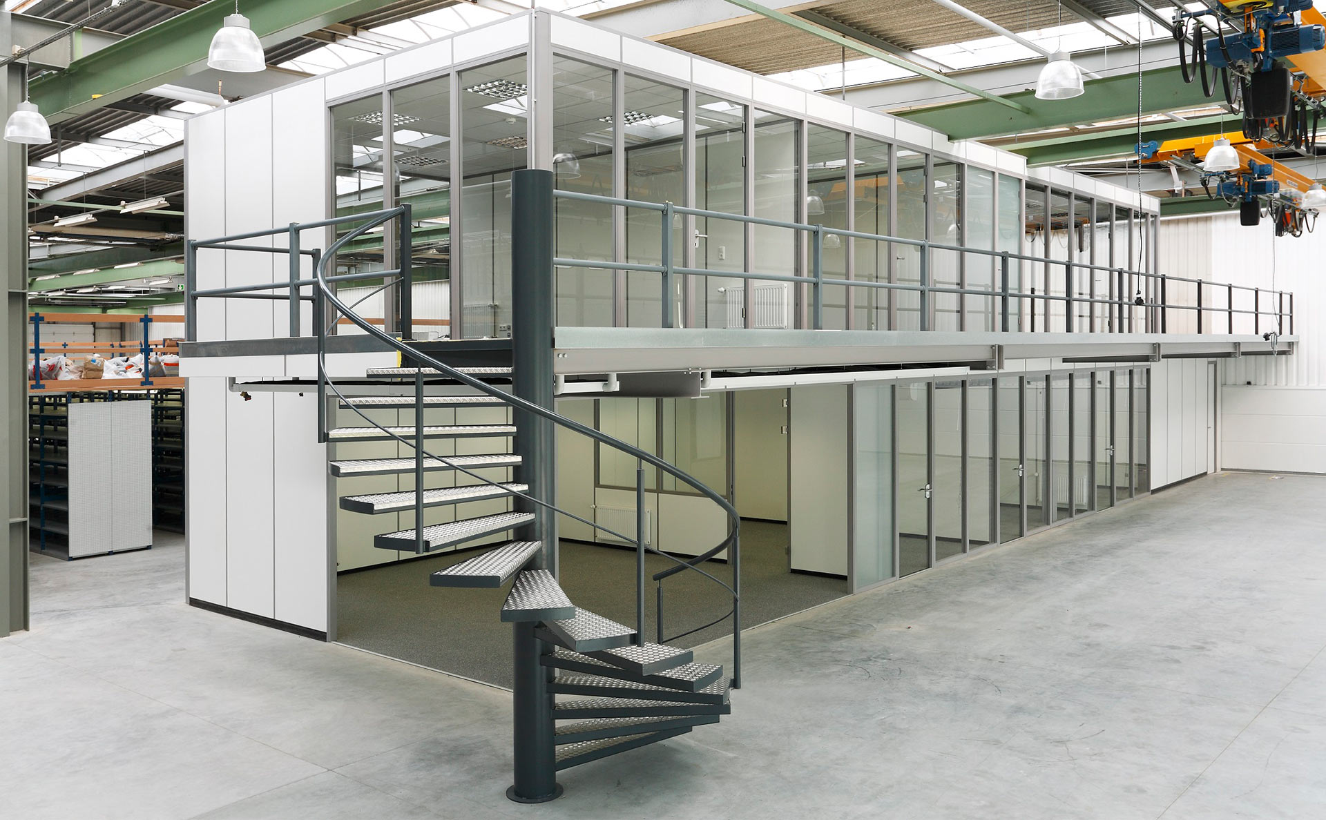 zweigeschossiges Hallenbüro mit Glaswänden auf Podest